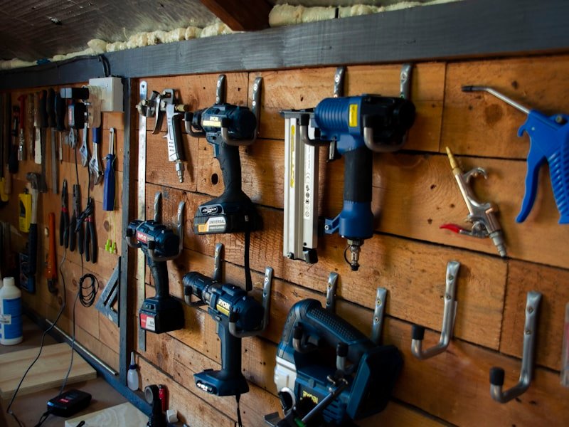 Organised workshop tool wall with drills, saws, and hand tools.