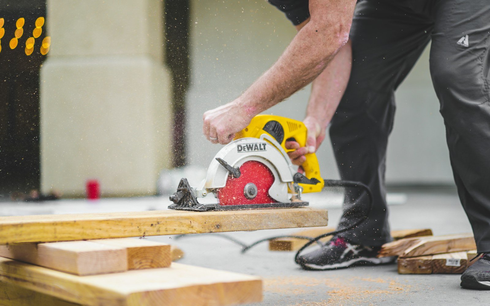 Handyman cutting lumber with a circular saw, sawdust in the air, on an Ottawa job site.