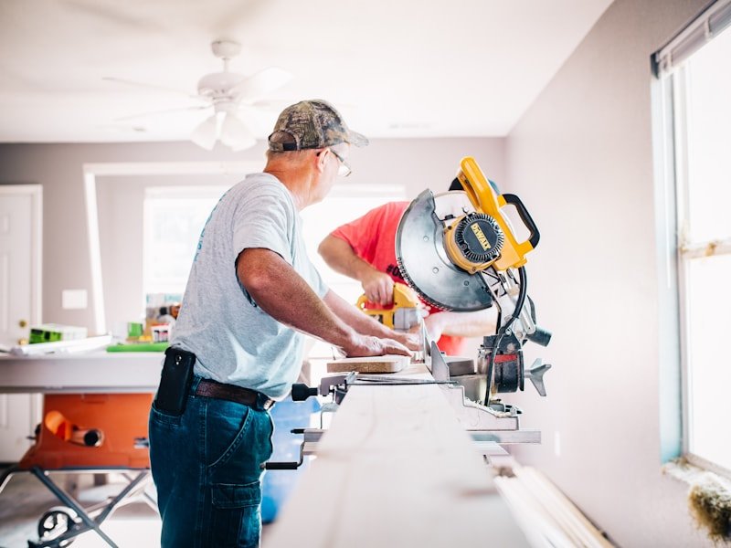 Carpenter at a miter saw cutting trim for an Ottawa home interior.